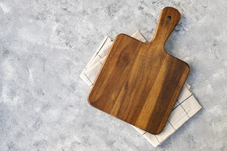 Cutting board over marble table background. Cooking backdrop. Top view with space for your recipe